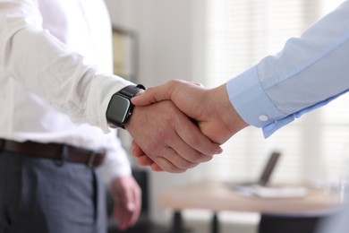 Photo of Men shaking hands in agreement indoors, closeup