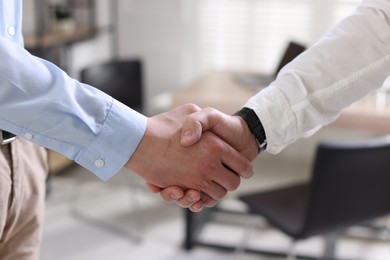 Photo of Men shaking hands in agreement indoors, closeup