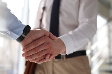 Photo of Men shaking hands in agreement indoors, closeup