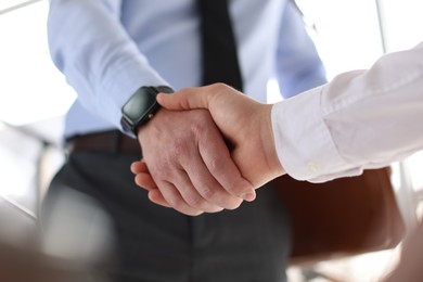 Photo of Men shaking hands in agreement indoors, closeup