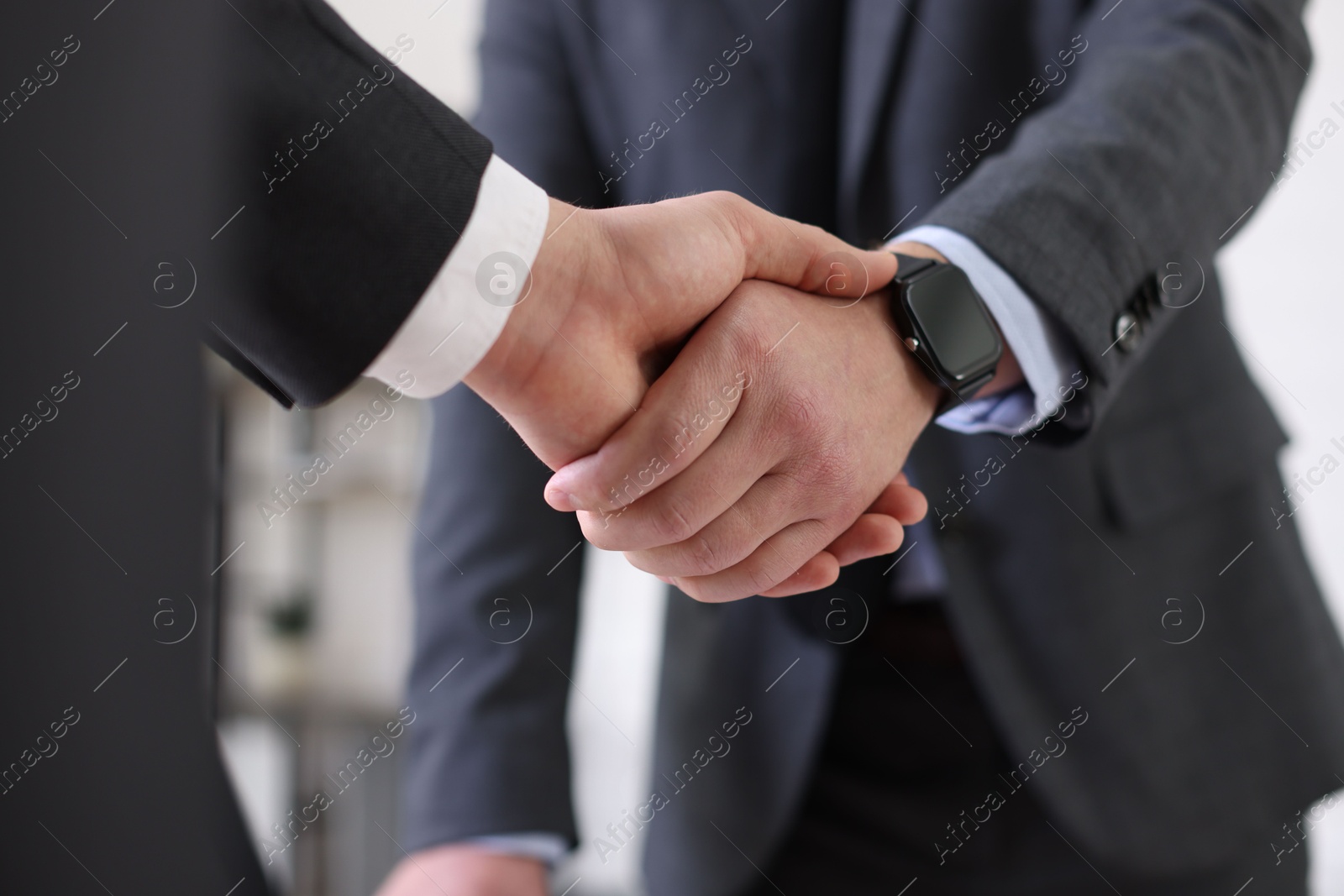 Photo of Men shaking hands during meeting in office, closeup