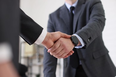 Photo of Men shaking hands during meeting in office, closeup