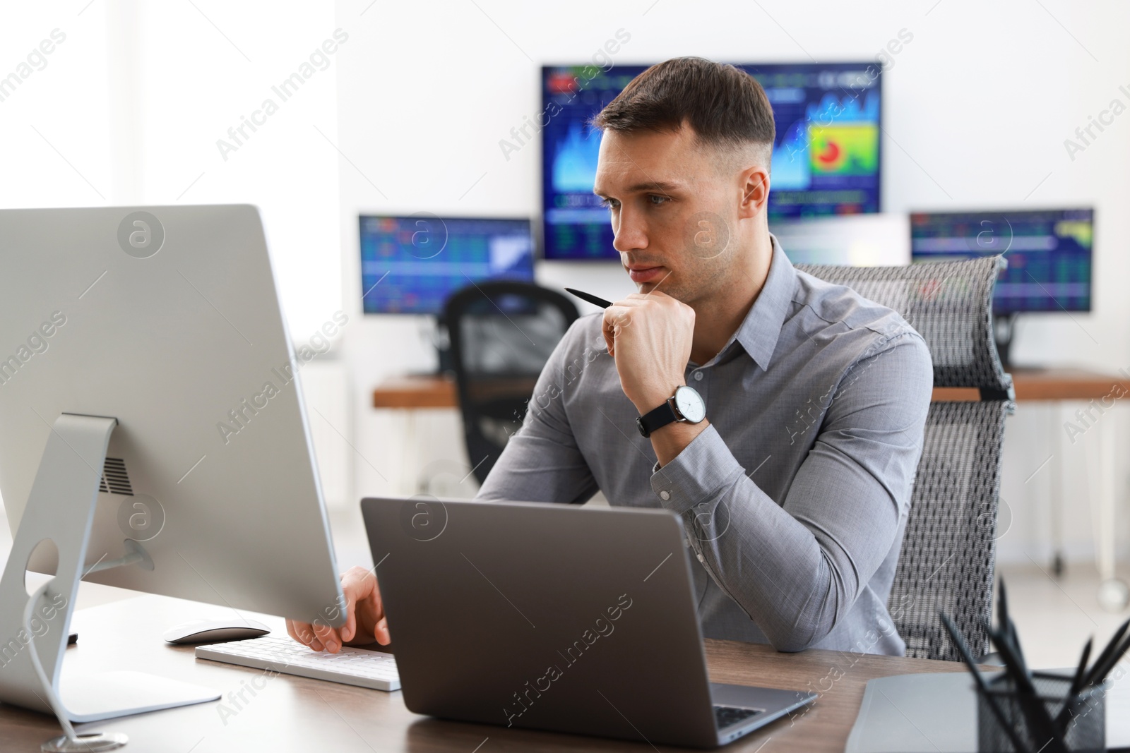 Photo of Financial trading specialist working on computer in office