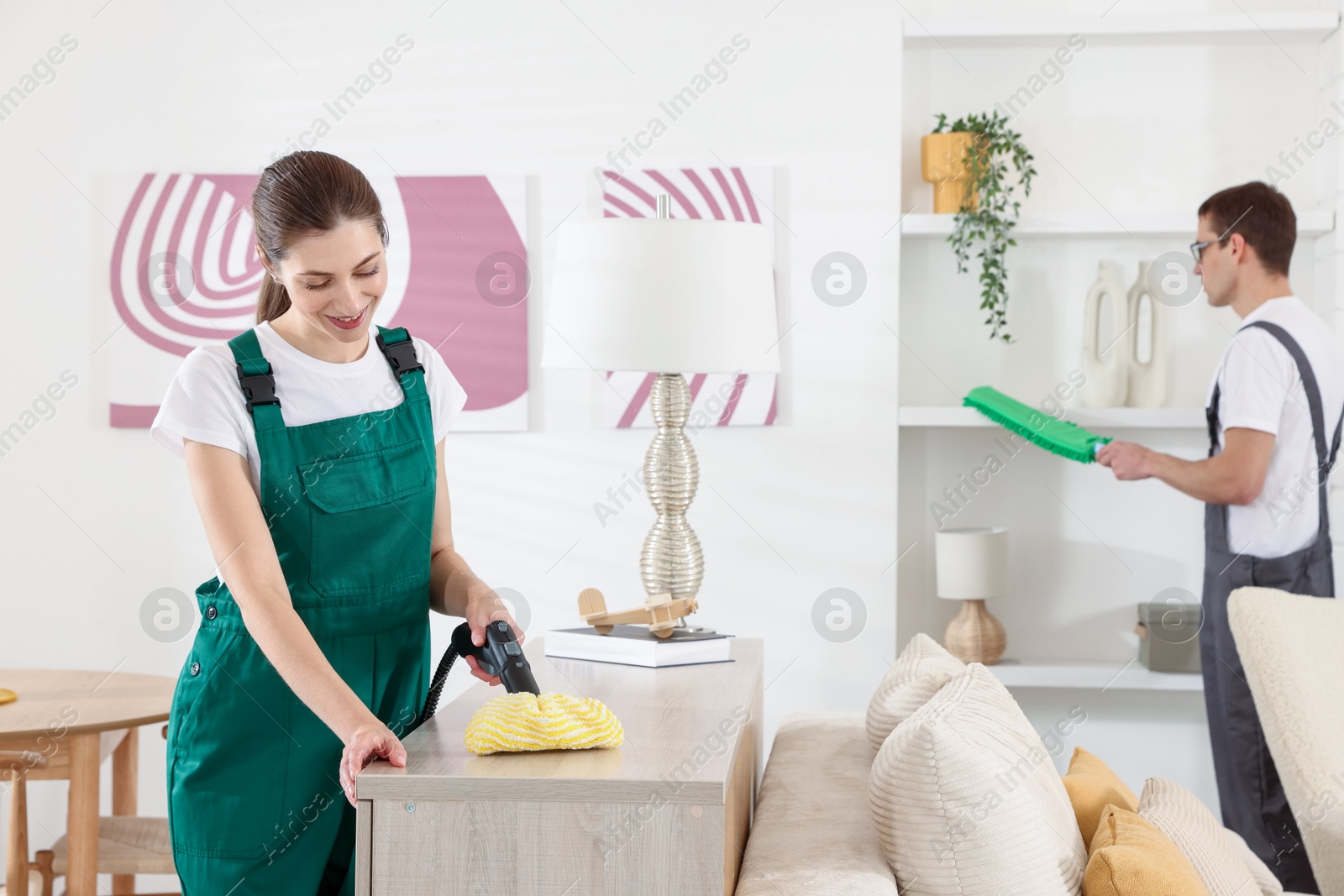 Photo of Professional cleaning service team working in room