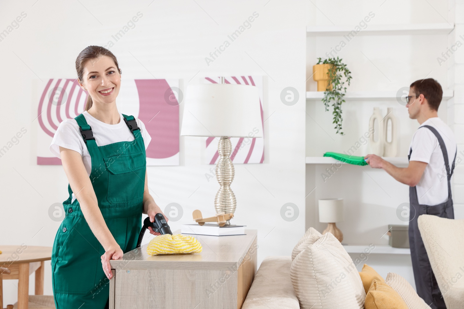 Photo of Professional cleaning service team working in room