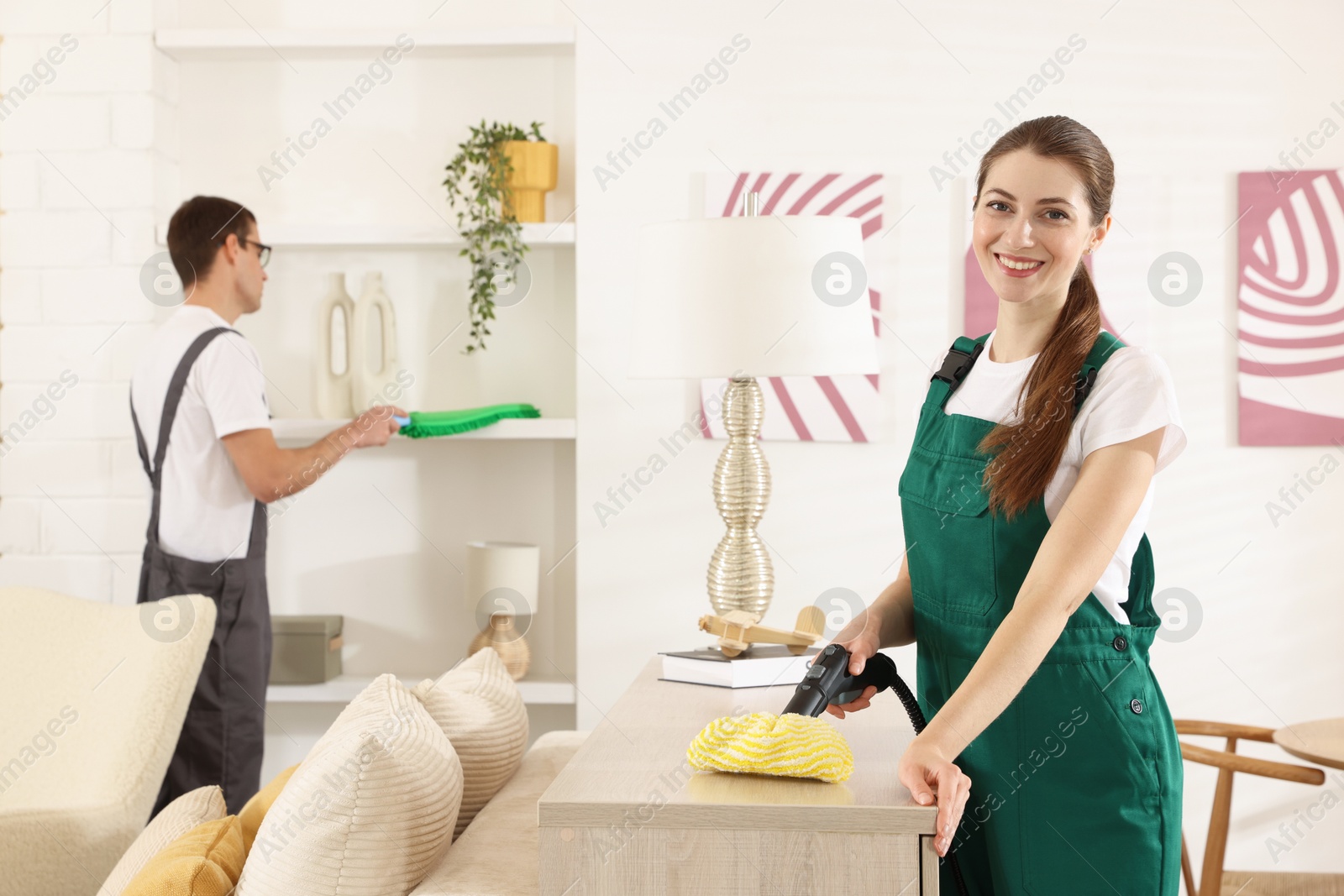 Photo of Professional cleaning service team working in room