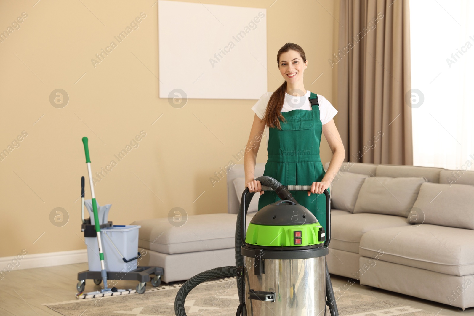 Photo of Cleaning service worker with professional hoover indoors