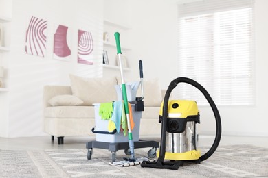 Photo of Professional hoover and cleaning supplies at home