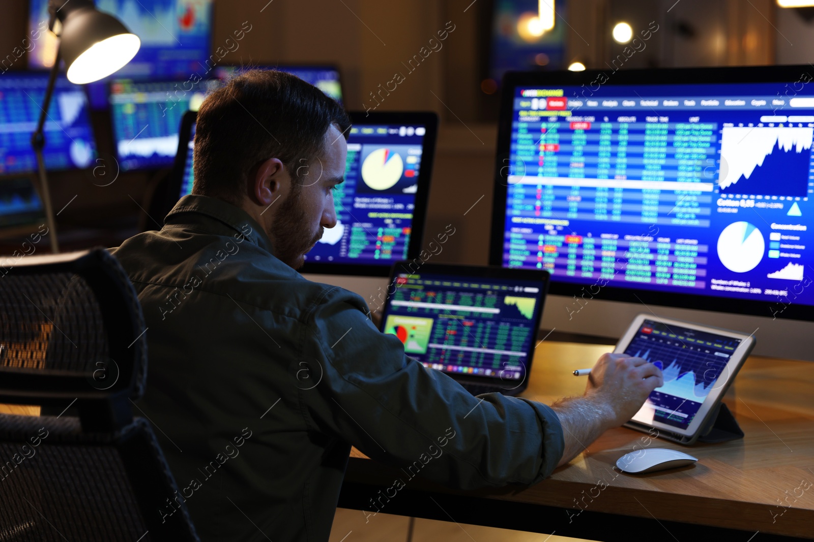 Photo of Financial trading specialist working in office at night