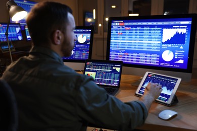 Photo of Financial trading specialist working in office at night, selective focus