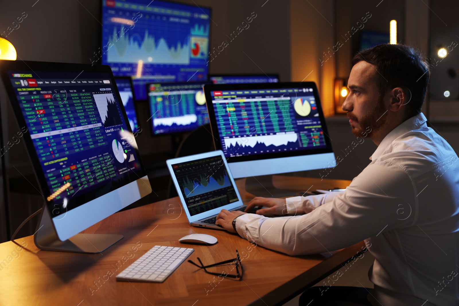 Photo of Financial trading specialist working in office at night