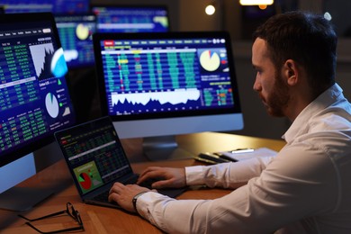 Photo of Financial trading specialist working in office at night