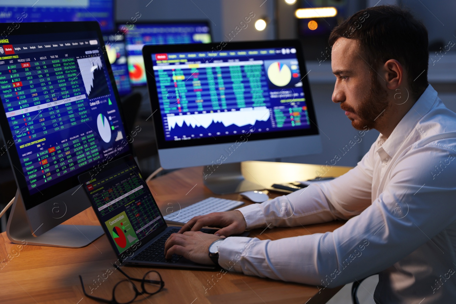 Photo of Financial trading specialist working in office at night