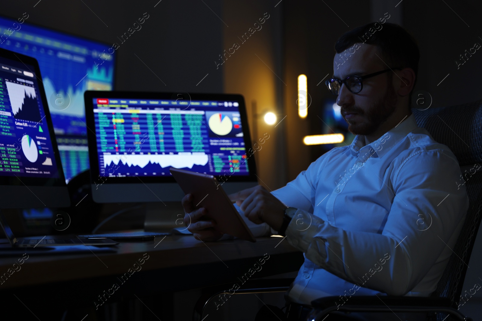 Photo of Financial trading specialist working in office at night