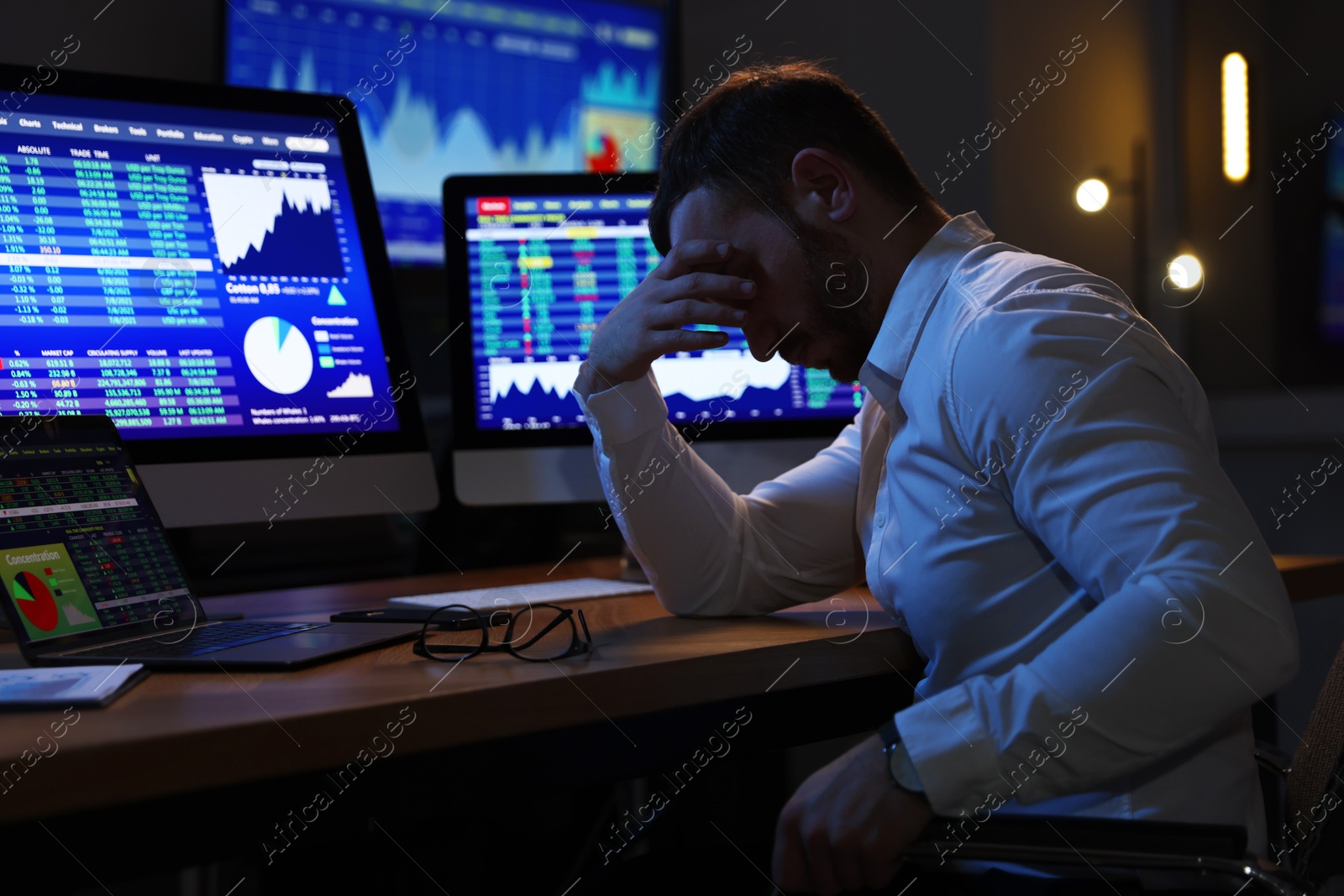 Photo of Tired overworked financial trading specialist napping in office at night