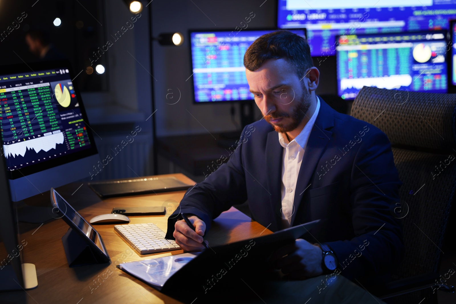 Photo of Financial trading specialist working in office at night