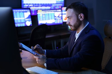 Photo of Financial trading specialist working in office at night