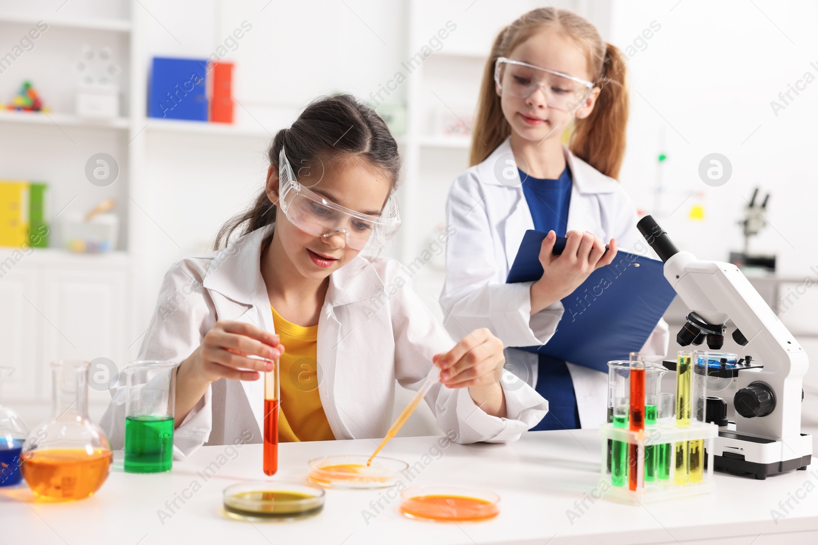 Photo of Children doing chemical experiment at desk indoors