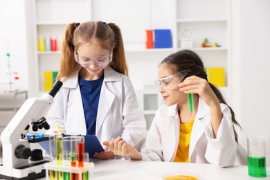 Photo of Children doing chemical experiment at desk indoors