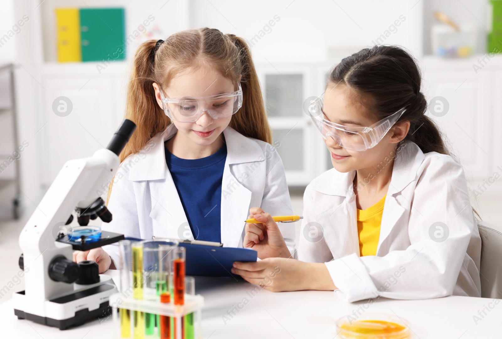 Photo of Children doing chemical experiment at desk indoors