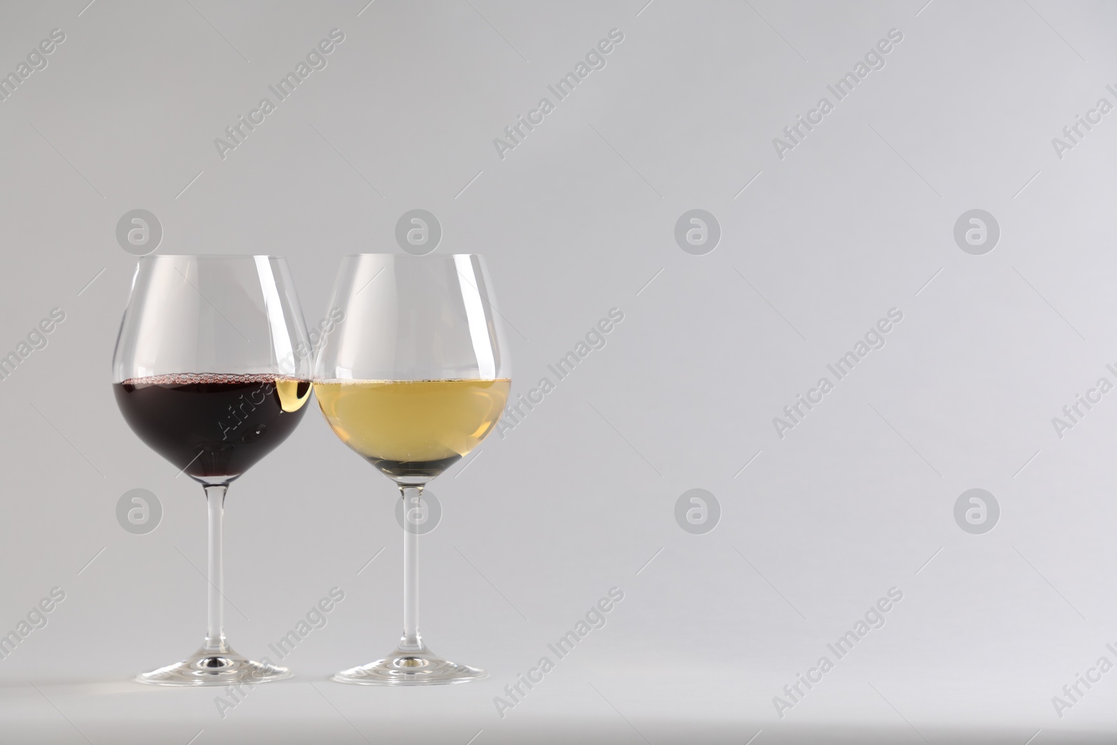 Tasty wine in glasses on white background, space for text Photo of Tasty wine in glasses on white background, space for text