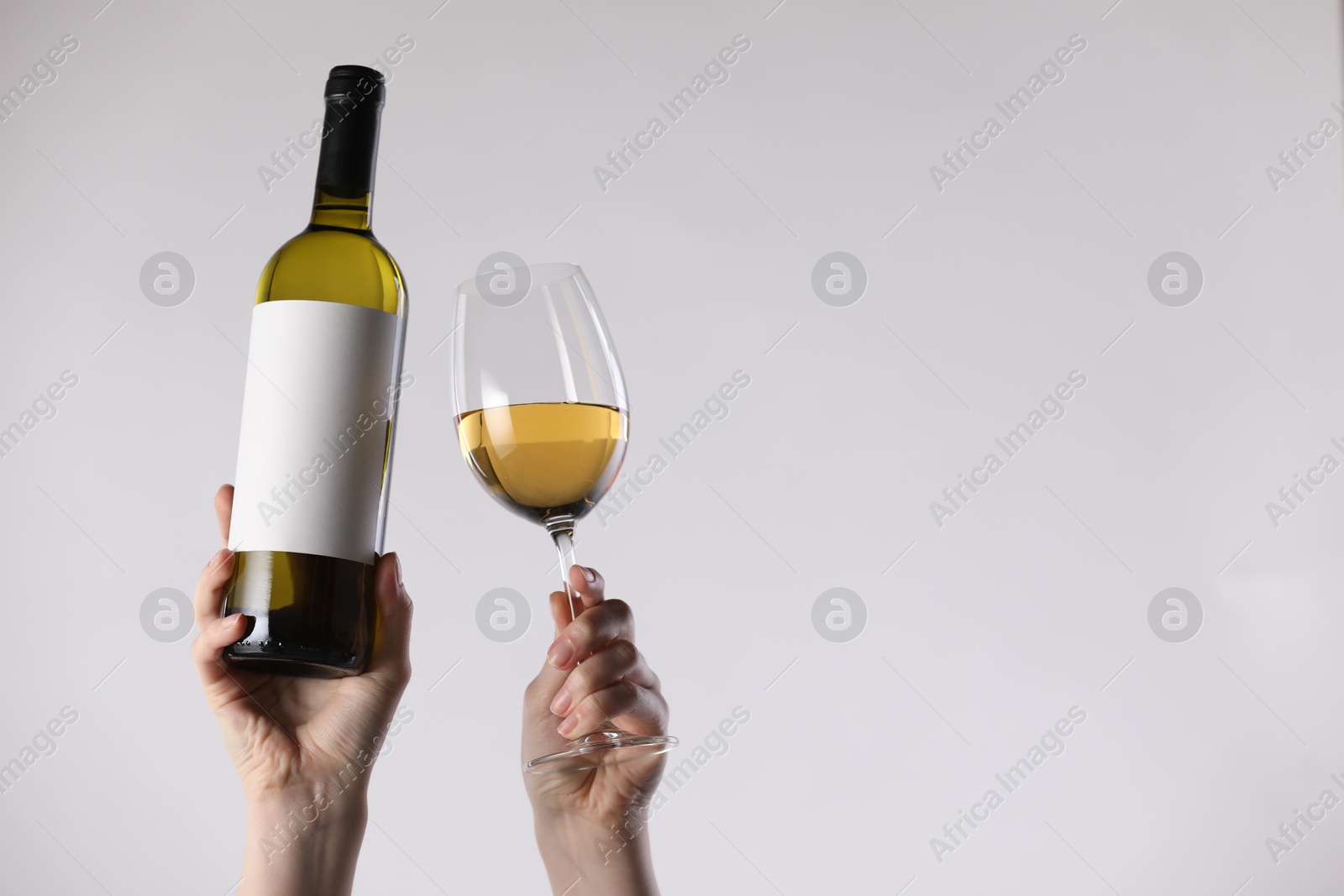 Woman with bottle of wine and glass on white background, closeup. Space for text Photo of Woman with bottle of wine and glass on white background, closeup. Space for text
