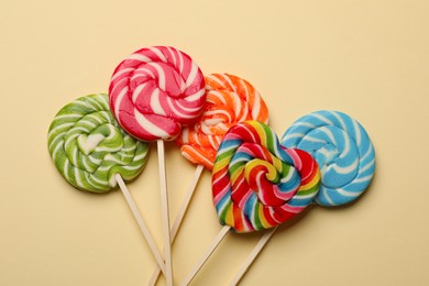 Tasty lollipops on beige background, flat lay