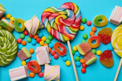 Photo of Many different tasty candies and marshmallows on light blue background, flat lay