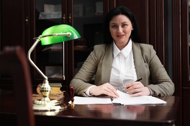 Smiling notary working at table in office