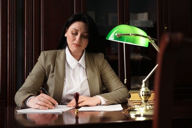 Notary working at table in dark office