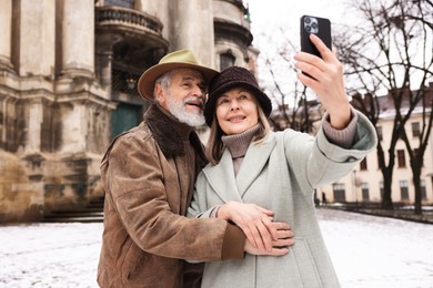 Happy senior couple taking selfie on winter day