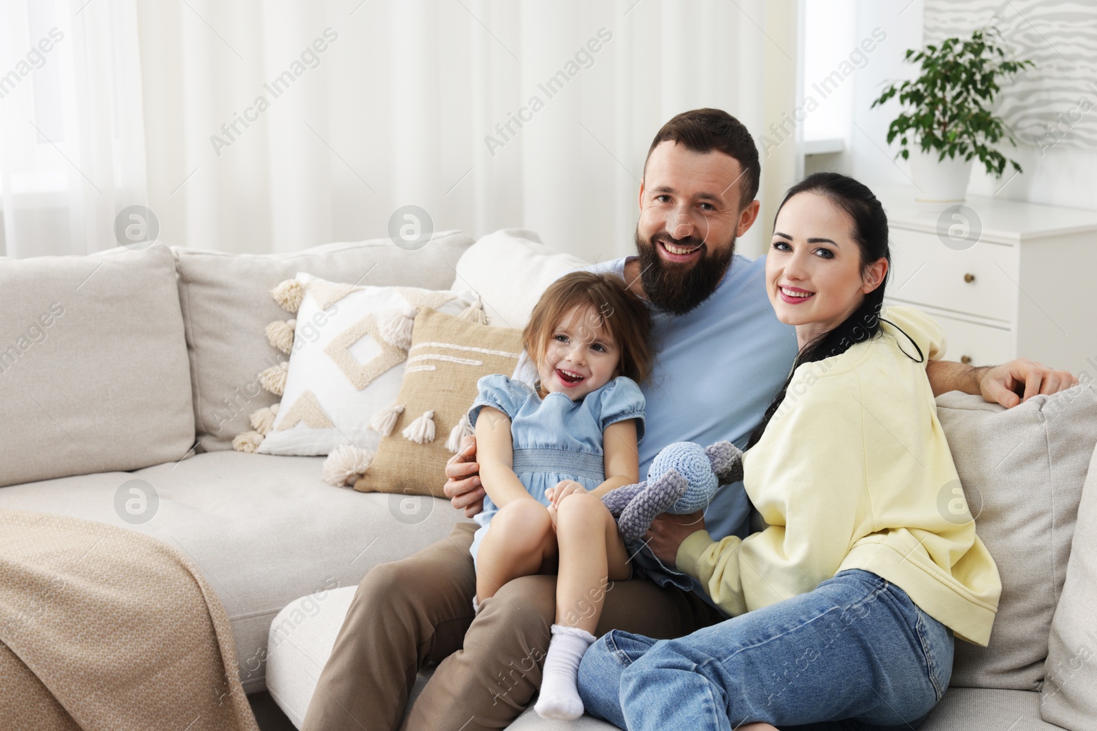 Photo of Portrait of cute little girl and her parents at home