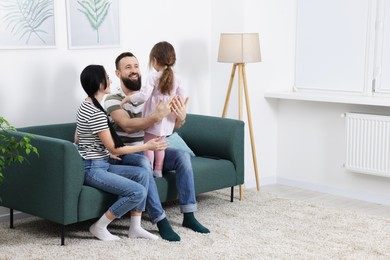 Photo of Cute little girl and her parents having fun at home