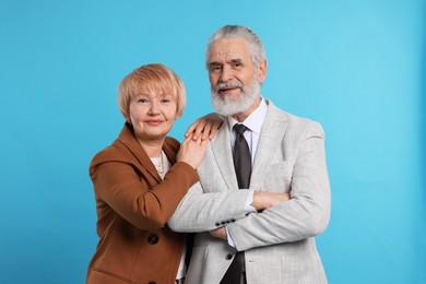 Portrait of lovely senior couple on light blue background