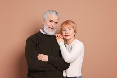 Portrait of lovely senior couple on beige background