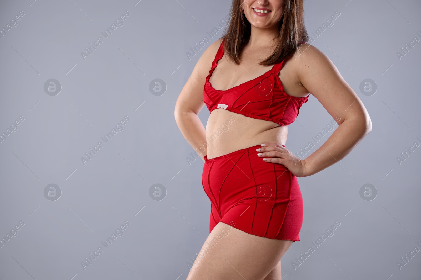 Photo of Cellulite problem. Woman in red underwear on light grey background, closeup. Space for text