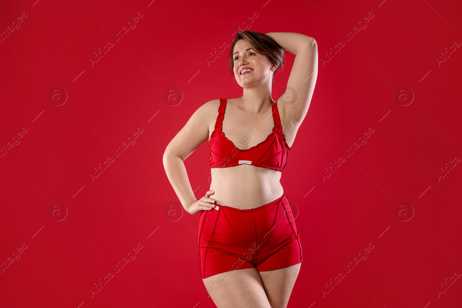 Photo of Woman in underwear on red background. Cellulite problem