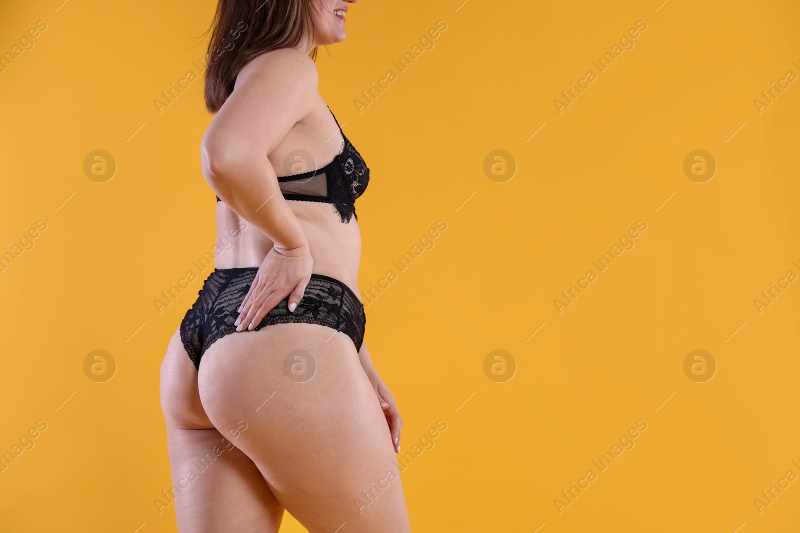 Photo of Cellulite problem. Woman in underwear on orange background, closeup. Space for text