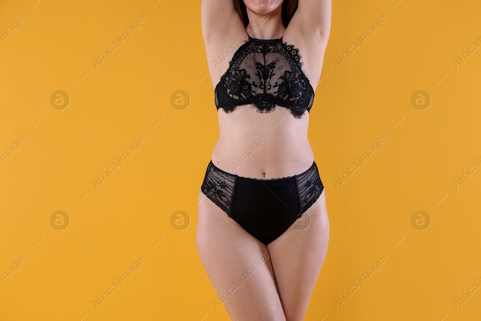 Photo of Woman in underwear on orange background, closeup. Cellulite problem