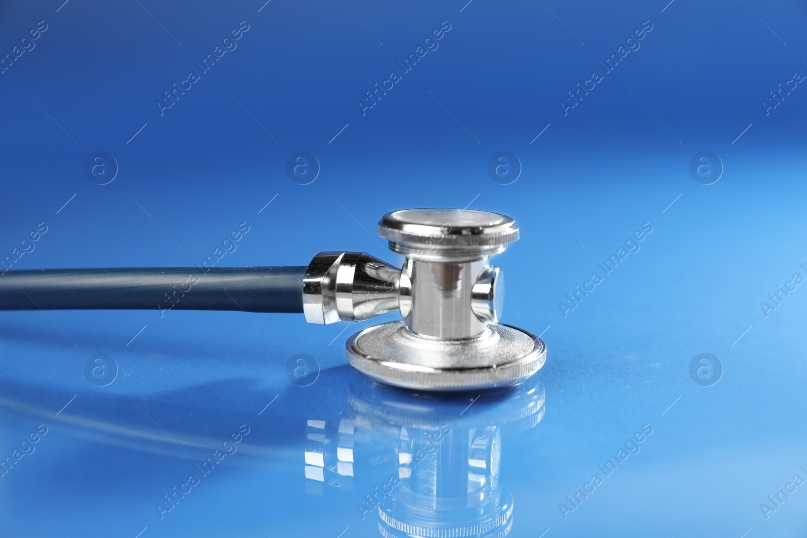 Stethoscope on blue background, closeup. Medical tool Photo of Stethoscope on blue background, closeup. Medical tool