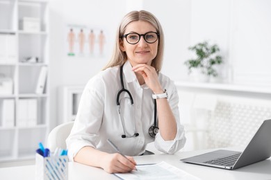 Professional doctor working at desk in hospital