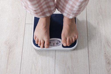 Woman on scales indoors, above view. Weight loss