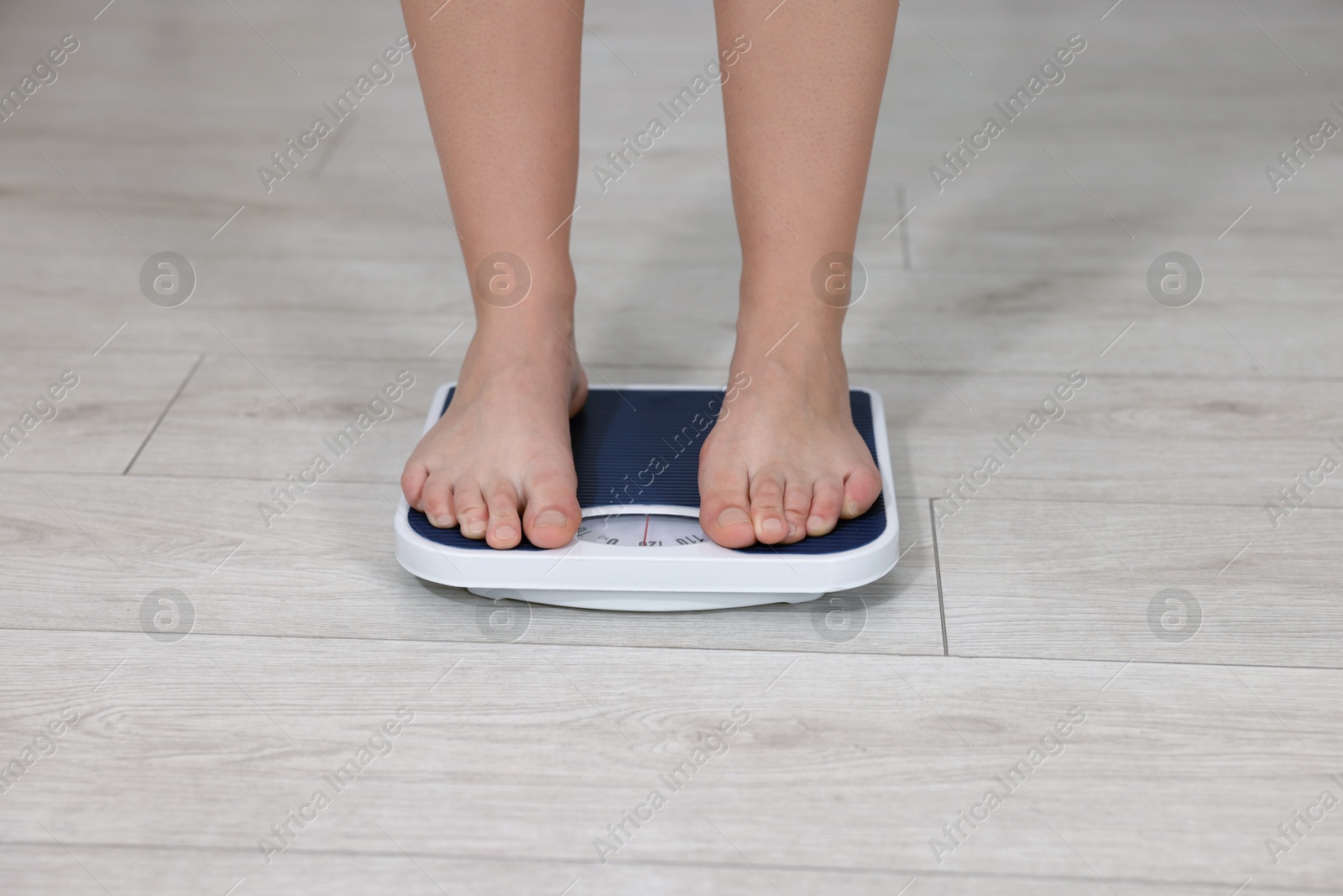 Photo of Woman on scales indoors, closeup. Weight loss