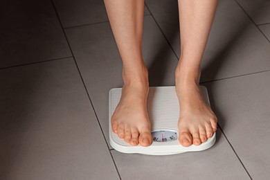 Photo of Bulimia problem. Woman on scales indoors, closeup. Space for text