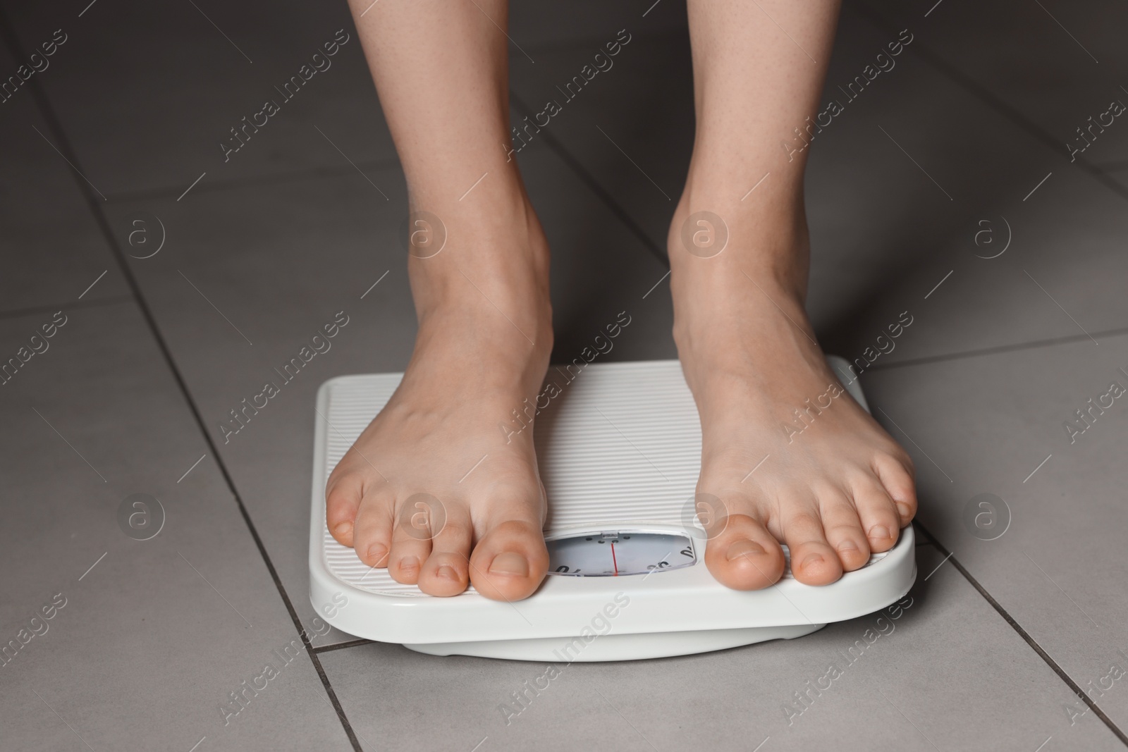 Photo of Woman on scales indoors, closeup. Bulimia problem