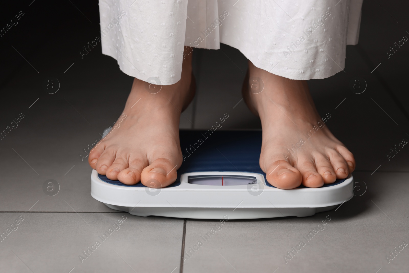 Photo of Woman on scales indoors, closeup. Bulimia problem