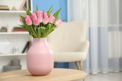 Photo of Bouquet of beautiful tulips in vase on wooden table indoors, space for text