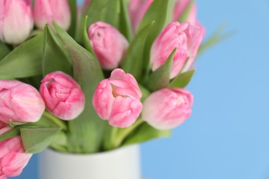 Photo of Bouquet of beautiful tulips on light blue background, closeup. Space for text