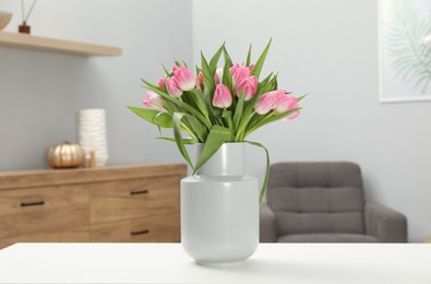 Photo of Bouquet of beautiful tulips in vase on white table indoors