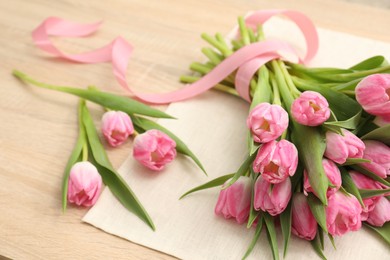 Photo of Bouquet of beautiful tulips on wooden table, closeup